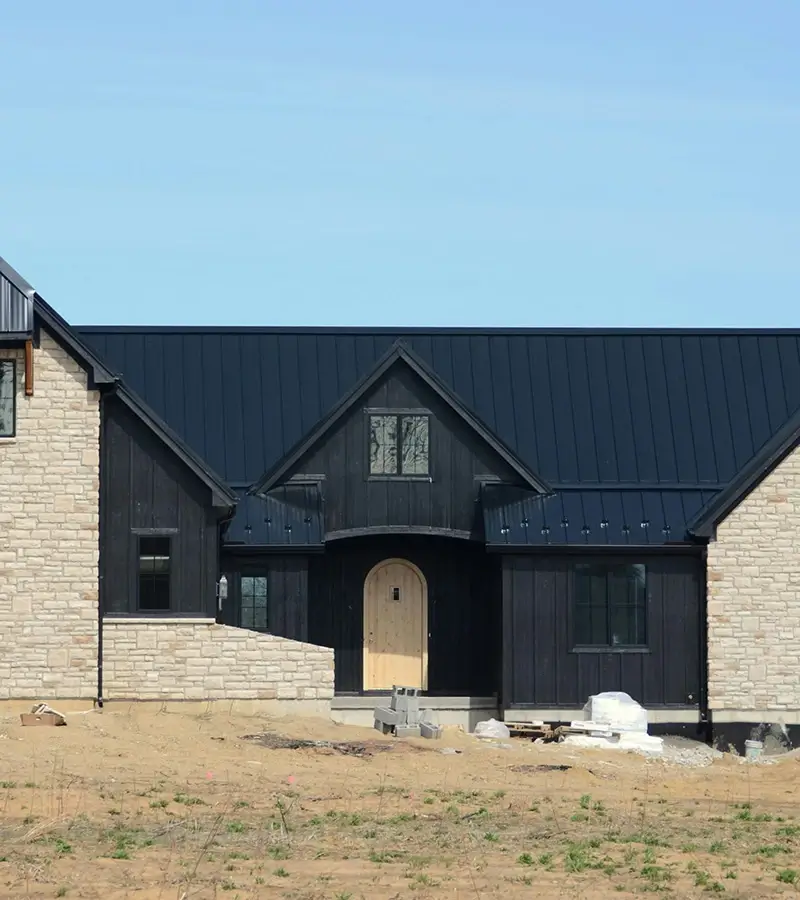 Modern farmhouse under construction with metal roof