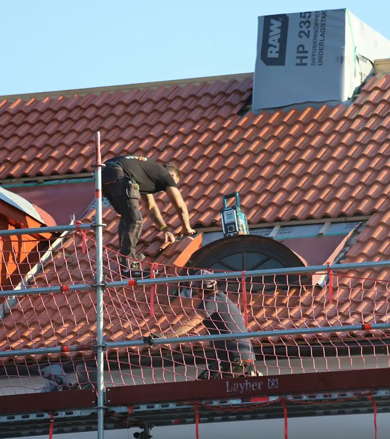 Two people installing tile roof