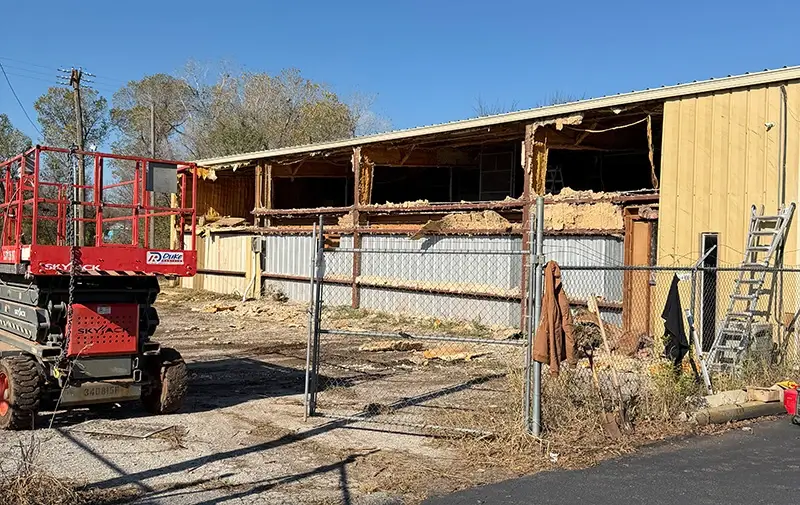 A shop with torn out paneling and no gutters